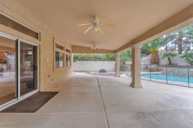 view of patio / terrace with a ceiling fan, a fenced backyard, a pool with connected hot tub, and a fire pit