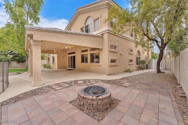 back of house with a tiled roof, stucco siding, a fenced backyard, a ceiling fan, and a patio