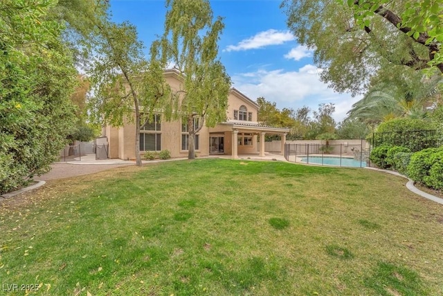 back of house with a patio area, stucco siding, and a lawn