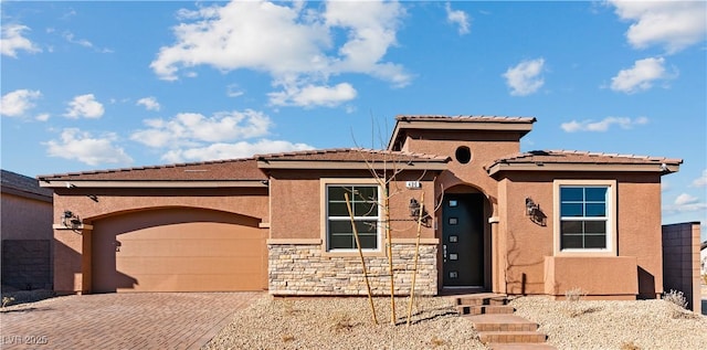 view of front of property featuring decorative driveway, an attached garage, and stucco siding