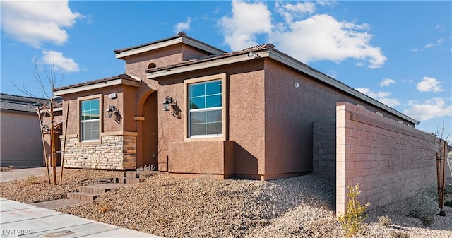 view of front of house featuring stucco siding and stone siding