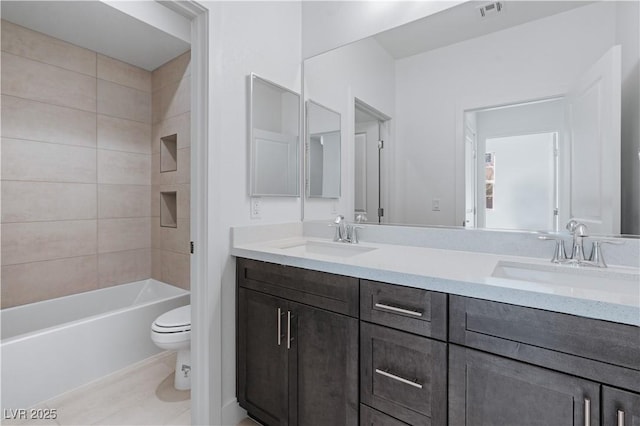 bathroom featuring double vanity, toilet, visible vents, and a sink