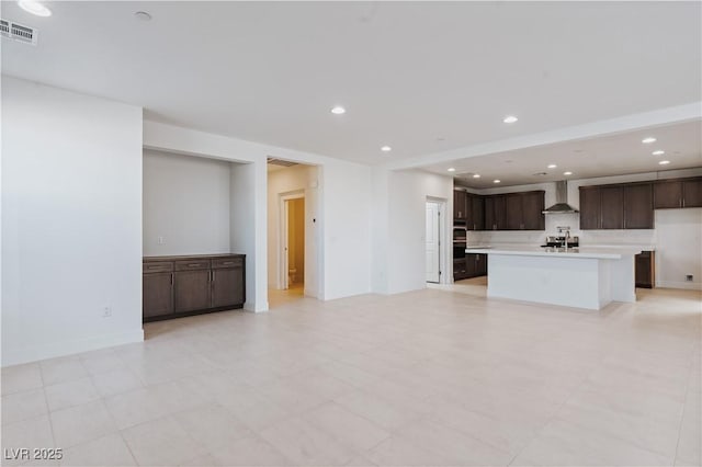 unfurnished living room with recessed lighting, visible vents, and baseboards