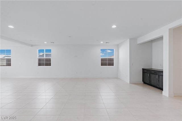 spare room featuring light tile patterned floors, recessed lighting, and baseboards