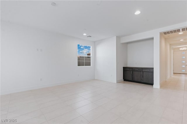 spare room featuring recessed lighting, visible vents, and baseboards