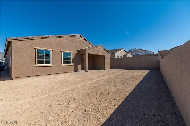 back of property featuring stucco siding and a fenced backyard