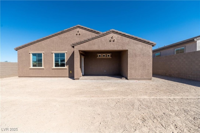 exterior space featuring stucco siding and fence