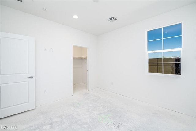 unfurnished bedroom with visible vents, unfinished concrete floors, recessed lighting, a closet, and a spacious closet