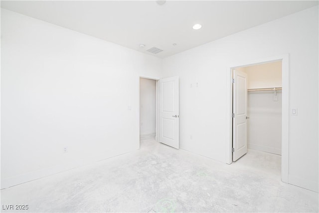 unfurnished bedroom with visible vents, recessed lighting, a closet, concrete flooring, and a spacious closet