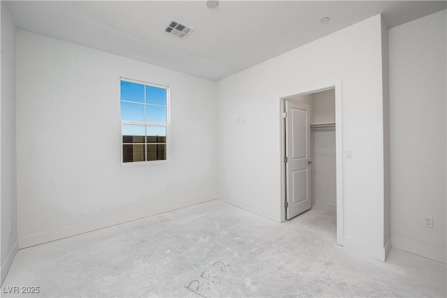 unfurnished bedroom with a spacious closet, visible vents, and baseboards