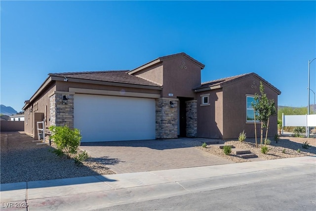 ranch-style house with decorative driveway, stone siding, and stucco siding