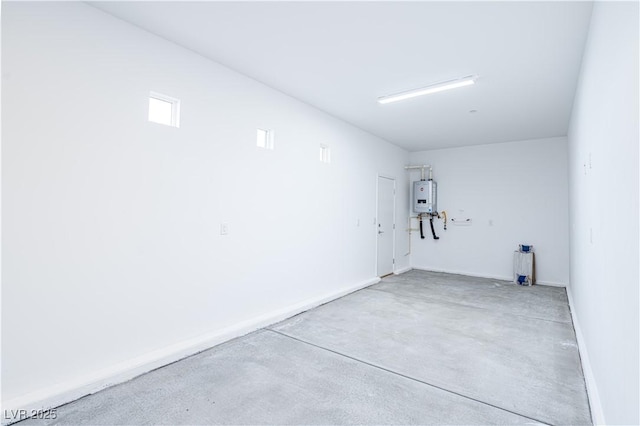 garage with baseboards and water heater