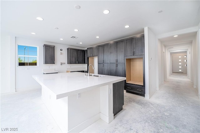 kitchen with visible vents, unfinished concrete floors, recessed lighting, a large island, and a sink