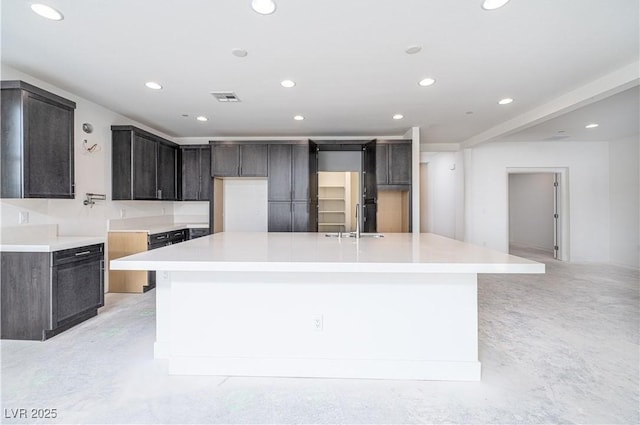 kitchen with visible vents, a large island, a sink, recessed lighting, and concrete flooring