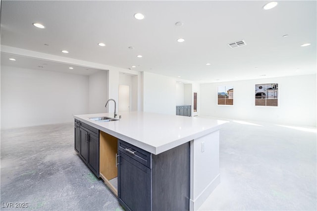 kitchen featuring unfinished concrete floors, visible vents, open floor plan, and a sink