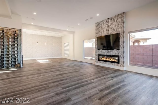 unfurnished living room with a fireplace, recessed lighting, and wood finished floors