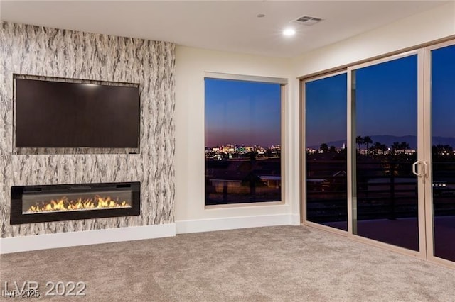 unfurnished living room with visible vents, carpet flooring, and a fireplace