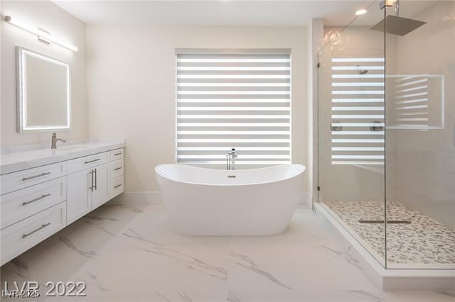 bathroom featuring marble finish floor, vanity, and a shower stall