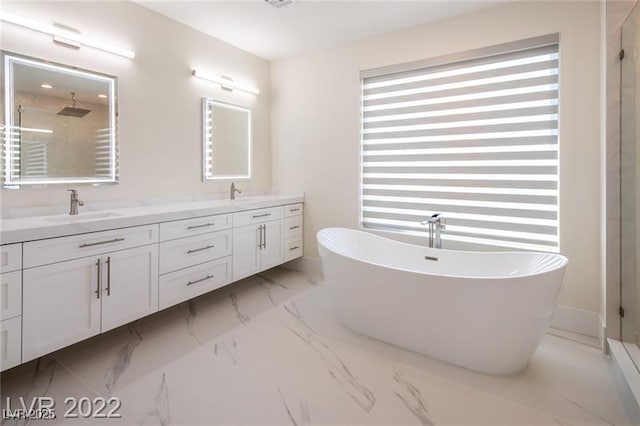 full bathroom featuring double vanity, a soaking tub, a stall shower, a sink, and marble finish floor