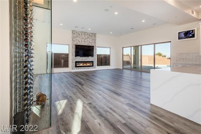 unfurnished living room with visible vents, recessed lighting, a large fireplace, and wood finished floors