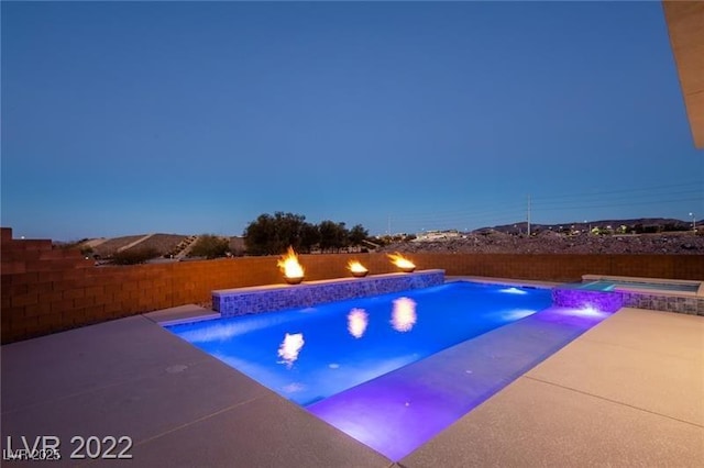 view of swimming pool featuring a pool with connected hot tub, a patio area, and a fenced backyard