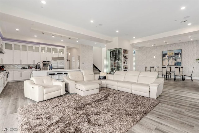 living area featuring visible vents, light wood-style flooring, recessed lighting, and wallpapered walls