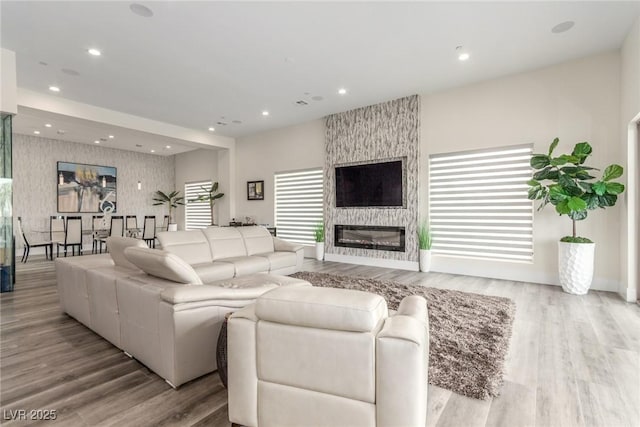 living room with a fireplace, wood finished floors, and recessed lighting