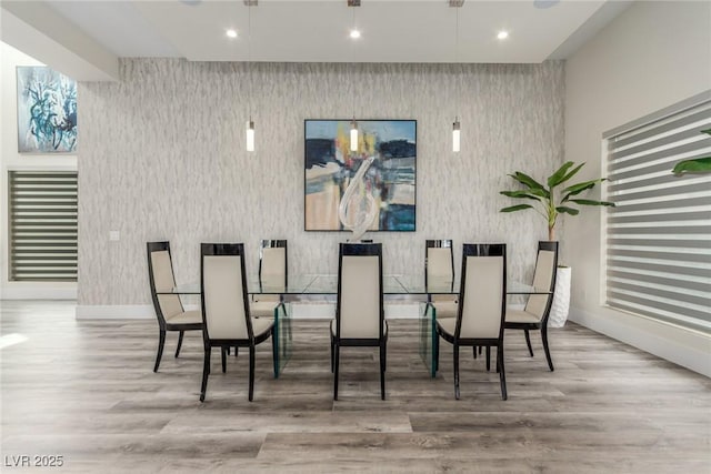 dining space with baseboards, wood finished floors, and recessed lighting