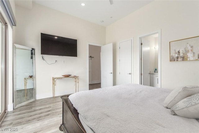 bedroom with ensuite bathroom, baseboards, light wood-style floors, and recessed lighting