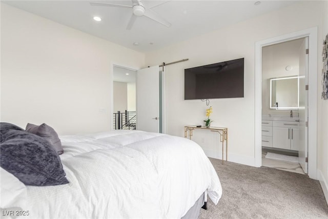 carpeted bedroom featuring recessed lighting, baseboards, ensuite bath, a barn door, and ceiling fan