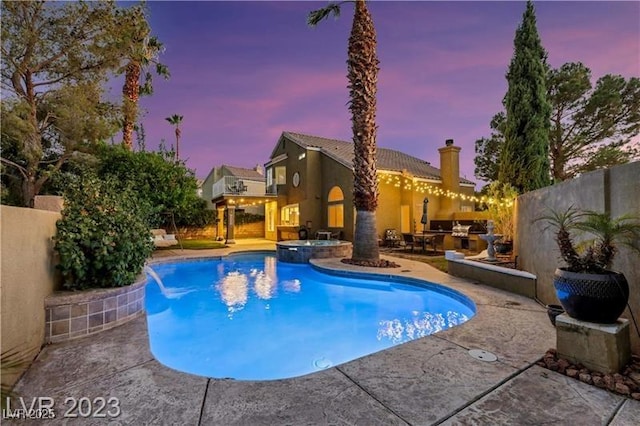 pool at dusk with a patio, a fenced backyard, and a pool with connected hot tub