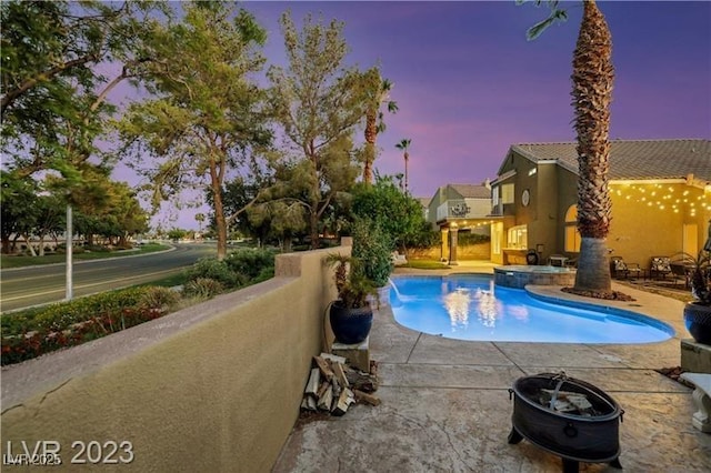 view of swimming pool featuring a patio and a pool with connected hot tub