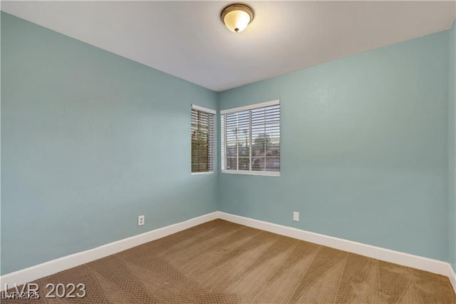 carpeted spare room with baseboards