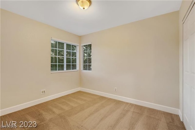 unfurnished room with carpet flooring and baseboards