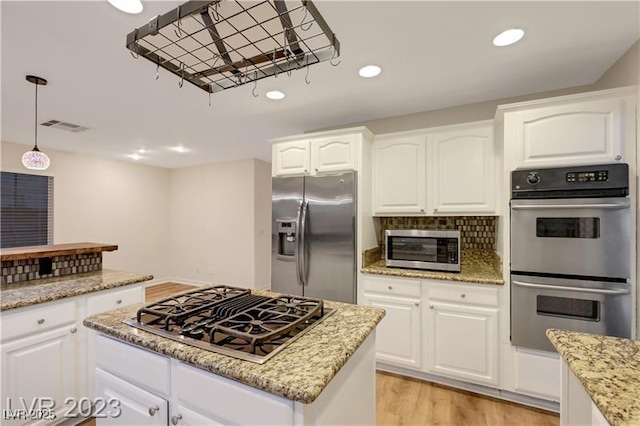 kitchen featuring light stone counters, decorative backsplash, recessed lighting, appliances with stainless steel finishes, and light wood-style floors