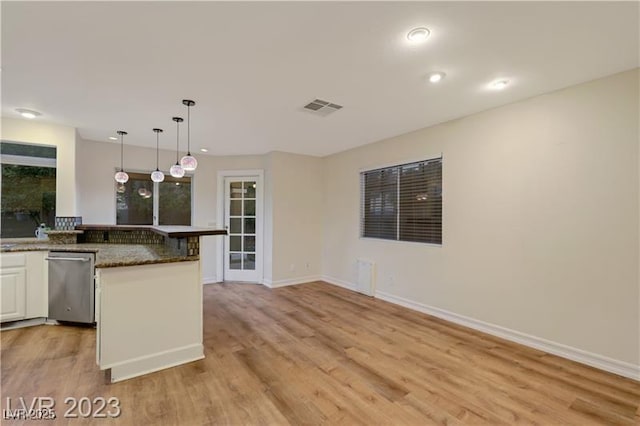 kitchen with visible vents, hanging light fixtures, white cabinets, light wood-style floors, and dishwasher