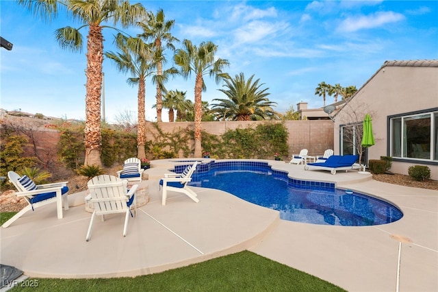 view of swimming pool featuring a fenced backyard, a pool with connected hot tub, and a patio