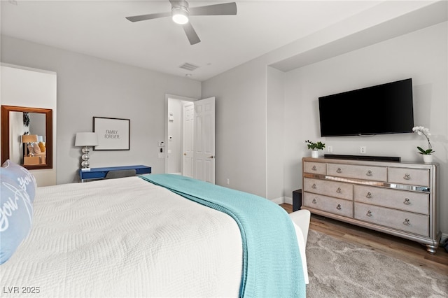 bedroom with wood finished floors, visible vents, and ceiling fan