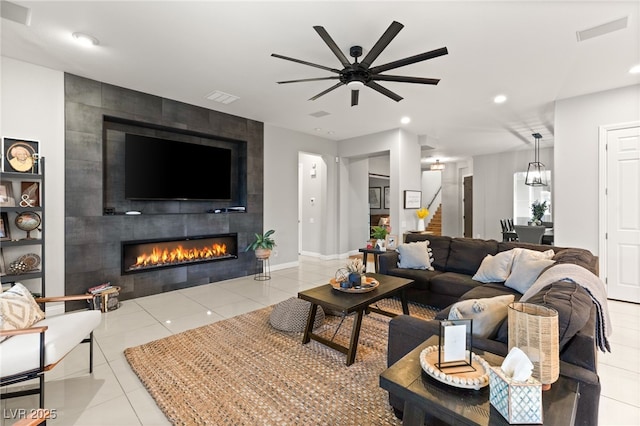 tiled living area featuring visible vents, recessed lighting, baseboards, ceiling fan, and a tile fireplace