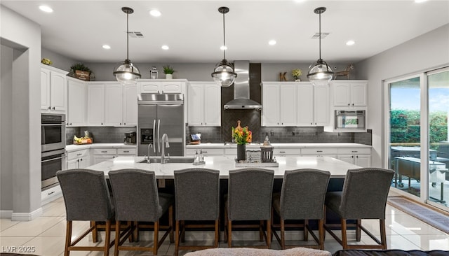 kitchen featuring visible vents, light tile patterned flooring, appliances with stainless steel finishes, white cabinetry, and wall chimney exhaust hood