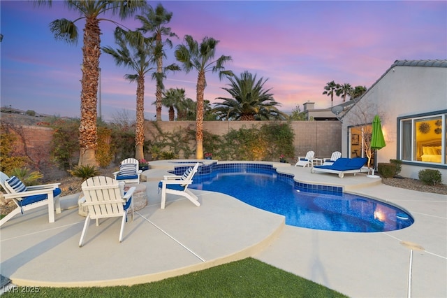 view of swimming pool with a fenced backyard, a pool with connected hot tub, and a patio