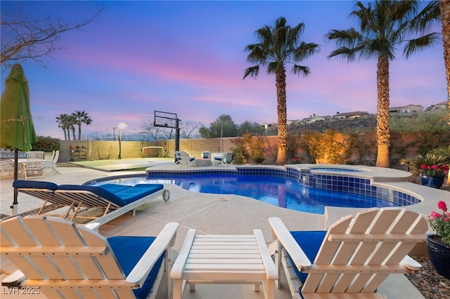 view of pool featuring a patio area, fence, and a pool with connected hot tub