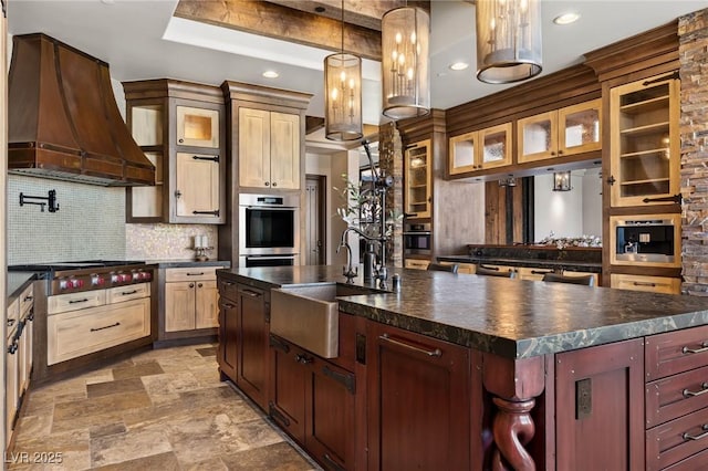 kitchen with custom range hood, a sink, dark countertops, backsplash, and stainless steel appliances