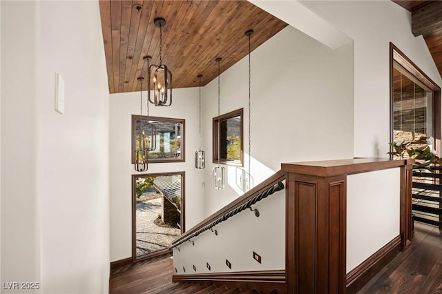 stairs featuring a notable chandelier, wooden ceiling, lofted ceiling, and wood finished floors