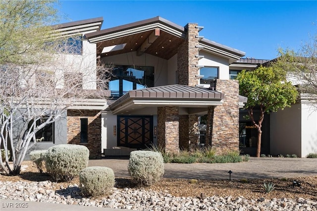 64 Promontory Ridge Dr, Las Vegas, NV 89135 - view of front of home featuring stone siding, a balcony, and stucco siding