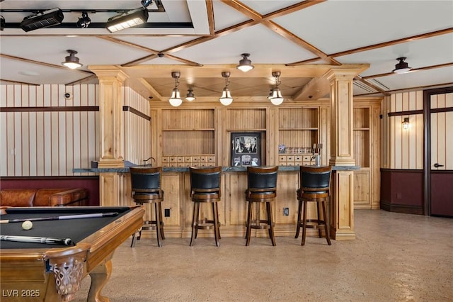 interior space featuring ornate columns, a peninsula, open shelves, dark countertops, and light speckled floor