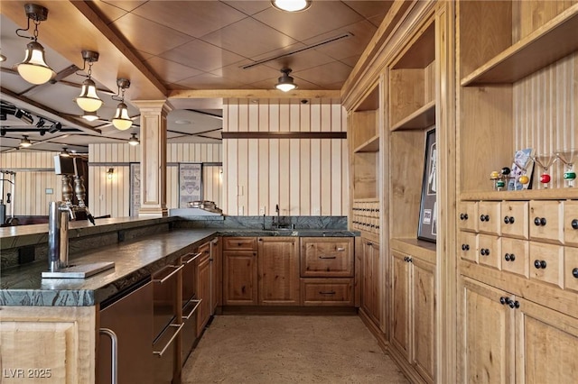 kitchen with pendant lighting, a sink, open shelves, a peninsula, and decorative columns