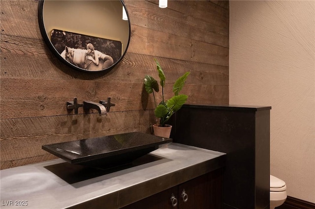 64 Promontory Ridge Dr, Las Vegas, NV 89135 - bathroom featuring vanity, toilet, and wood walls