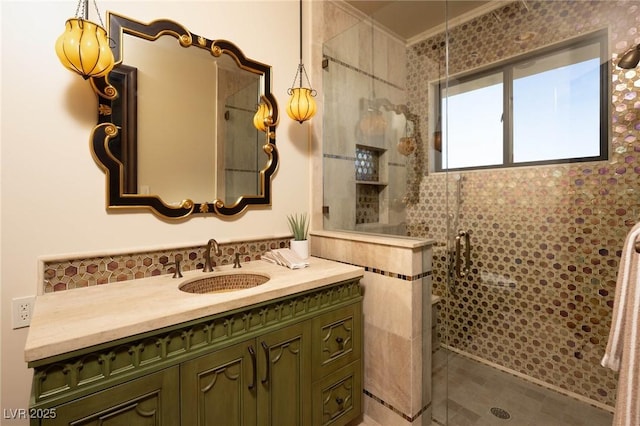 full bath featuring tiled shower, vanity, and ornamental molding