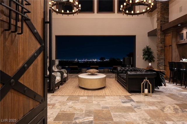 64 Promontory Ridge Dr, Las Vegas, NV 89135 - living room with a chandelier, stone finish flooring, and a high ceiling